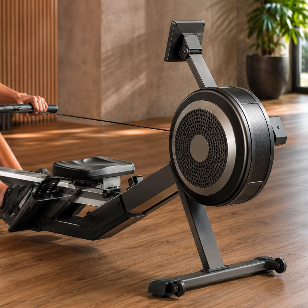 Person using a rowing machine on a wooden floor with a blurred background
